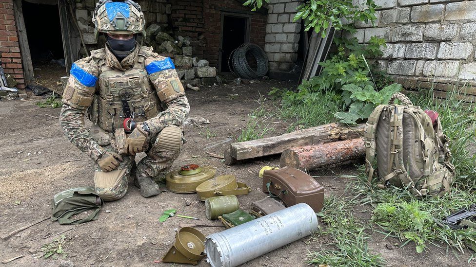 A soldier poses with Russian mines
