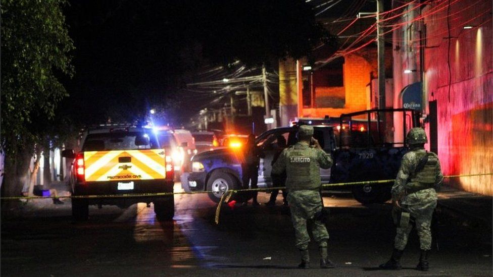 Солдаты охраняют место, где боевики открыли огонь в двух барах, убив минимум 10 человек, Селайя, Мексика, 23 мая 2022 г.