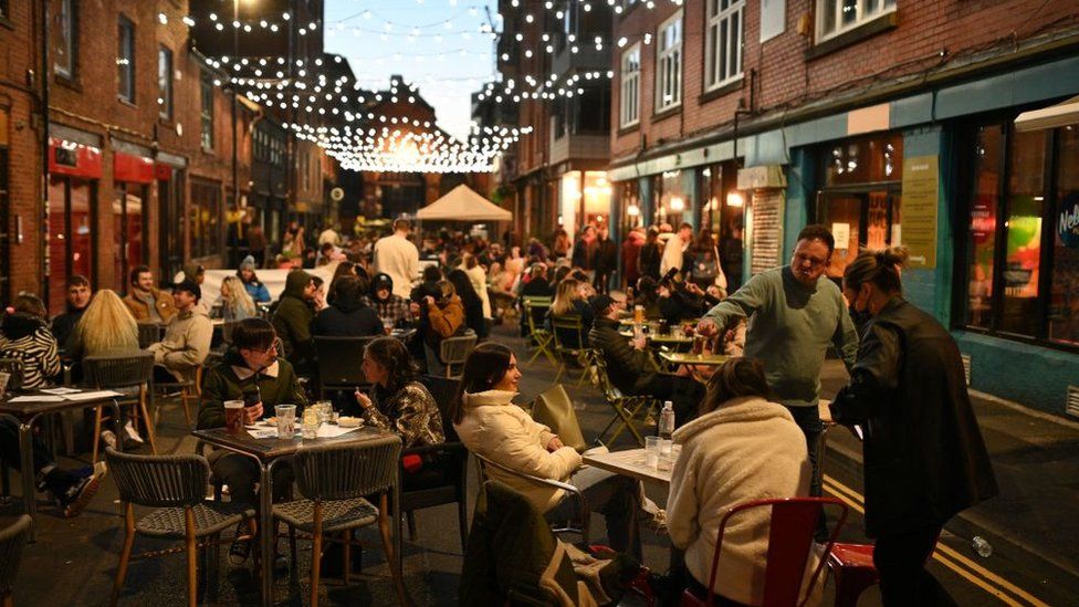 Customers enjoy drinks outside the bars in the Northern Quarter of central Manchester