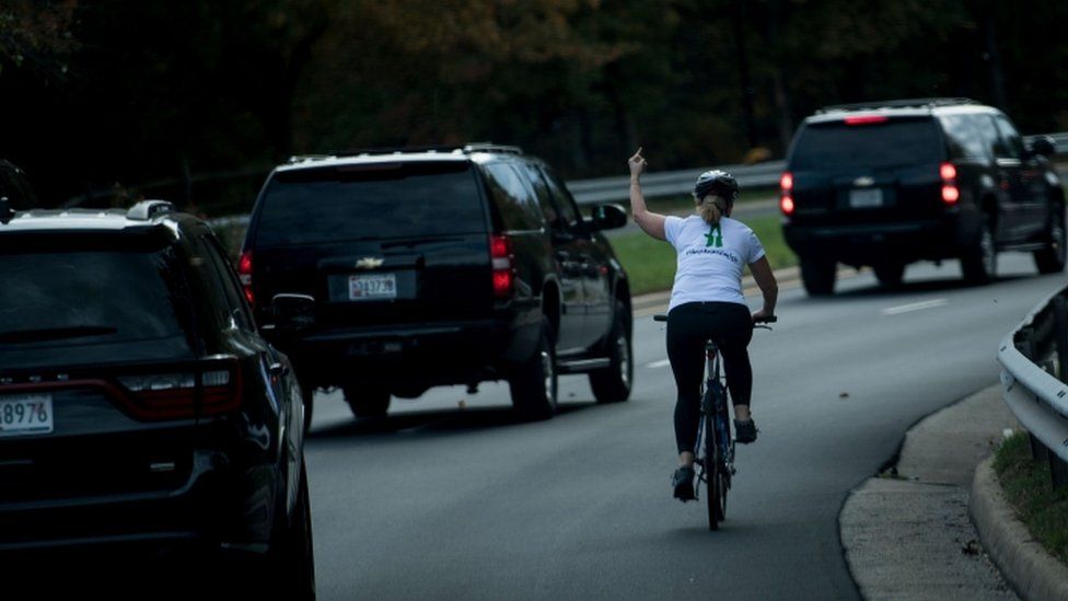 Ms Briskman cycling past the motorcade, making an obscene gesture.