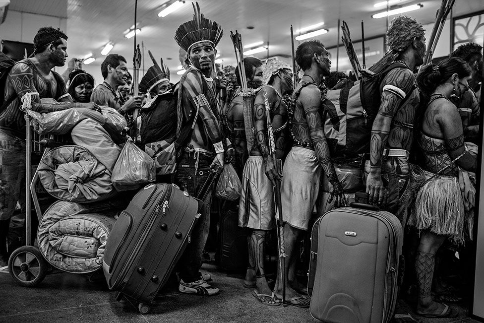 Members of the Munduruku community line up to board a plane at Altamira Airport, in Pará, Brazil, on 14 June 2013