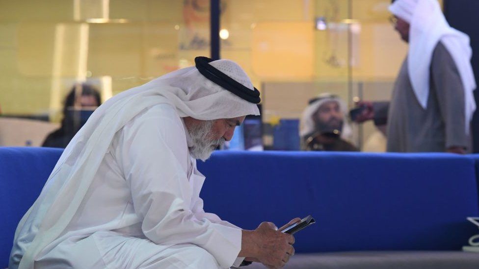 Man in Dubai uses a mobile phone