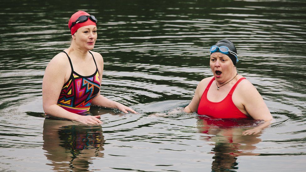 two women swimming in cold water