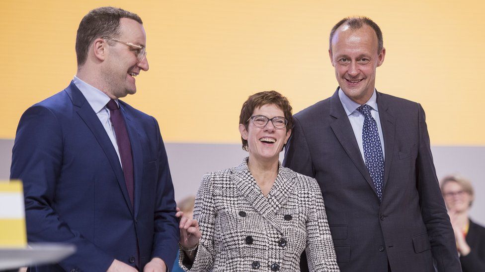 Annegret Kramp-Karrenbauer stands after receiving the most votes to become the next leader of the German Christian Democrats (CDU) between Jens Spahn (L) and Friedrich Merz (R)