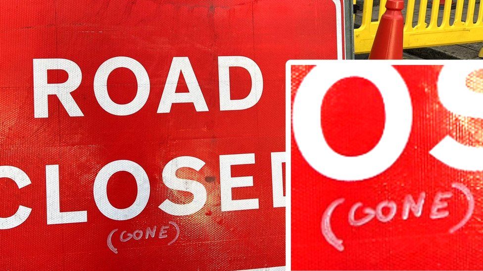 Red sign with "road closed" written on it