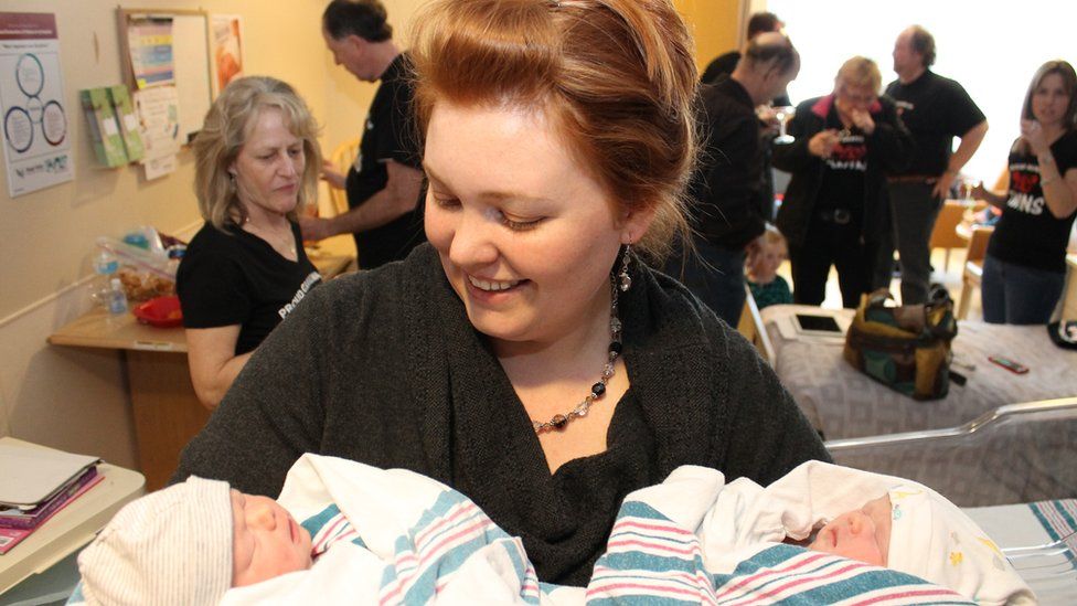 Sally Rhoads-Heinrich holding two babies