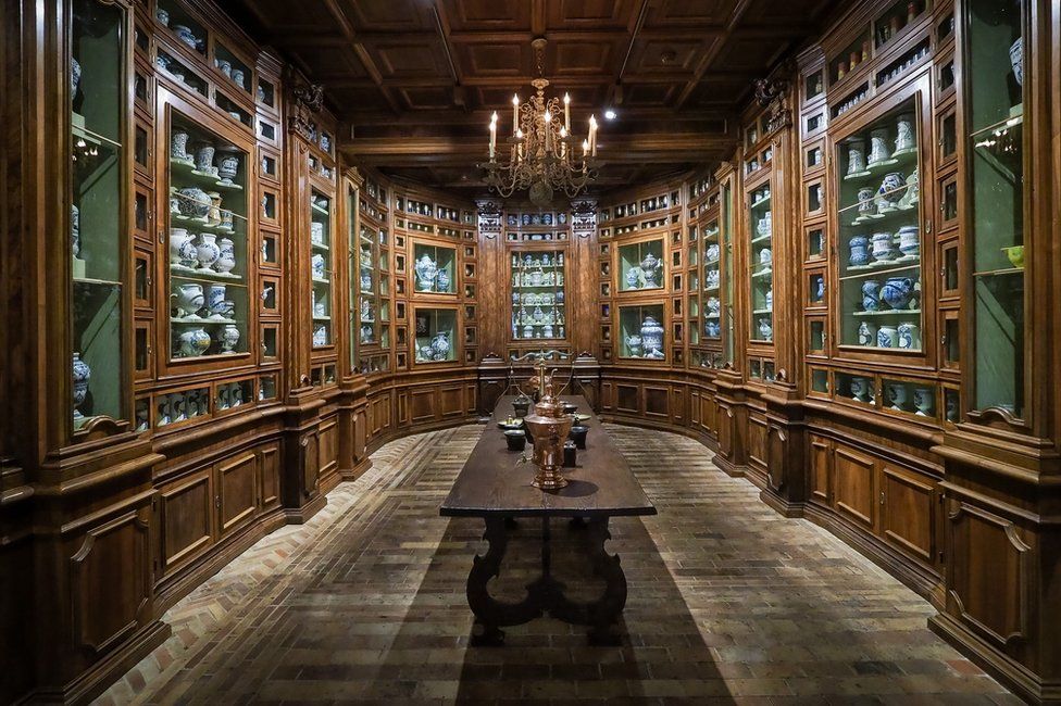 A room with many draws and cabinets containing bottles
