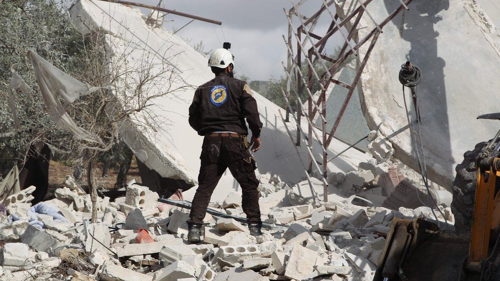 A Syrian first responder from the White Helmets group stands at the scene of a reported air strike in Jaballa (2 November 2019)