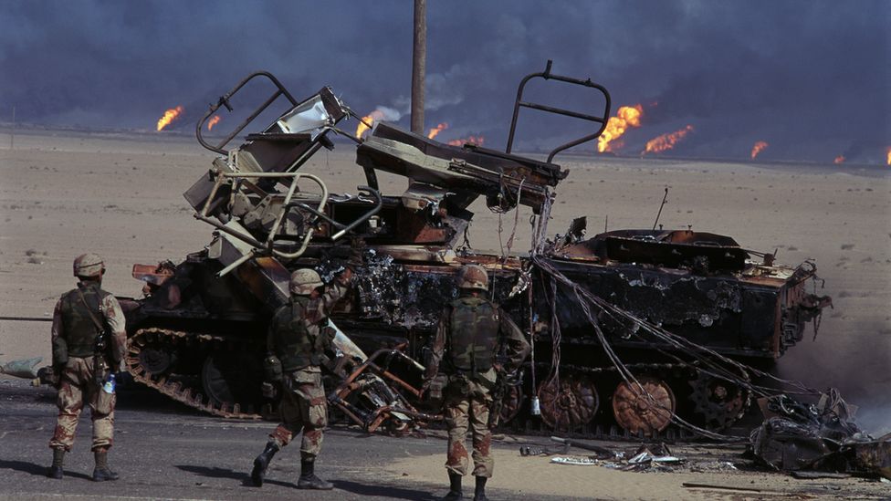 US troops surround a destroyed tank in Iraq War of 2003