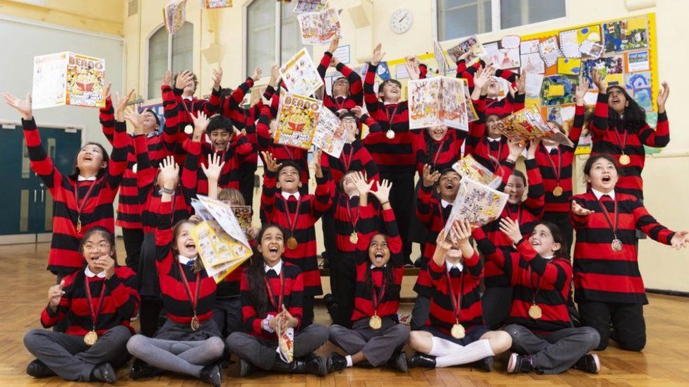 Students from Year 6 at Northside Primary School wear red and black striped jumpers and throw Beano comics in the air as they celebrate