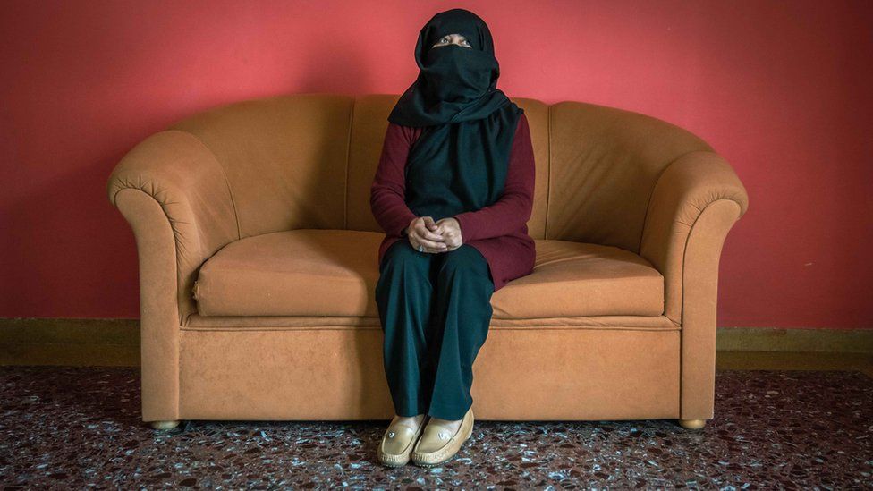 Sana sits defiant on the sofa of her temporary accommodation in Greece.