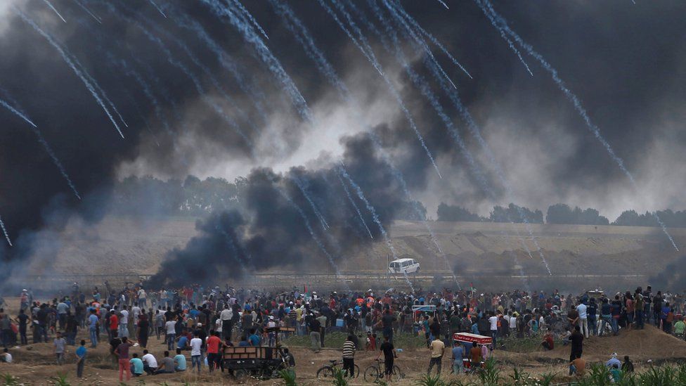 Tear-gas canisters are fired by Israeli troops towards Palestinians protesting on the Gaza-Israel border on 4 May 2018