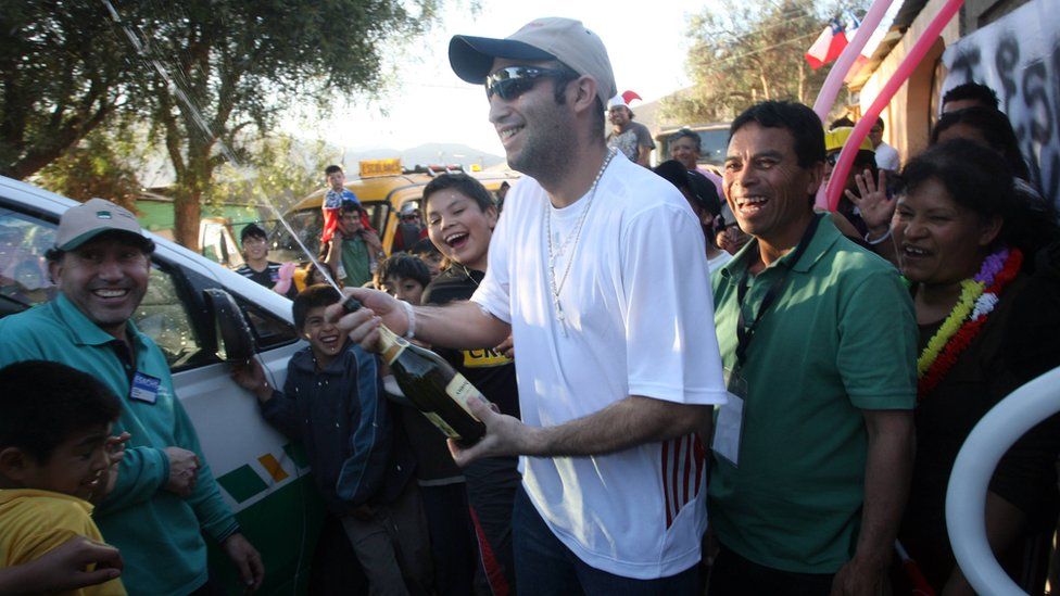 Carlos Barrios celebrates with champagne as he arrives home in Copiapo on 15 October 2010