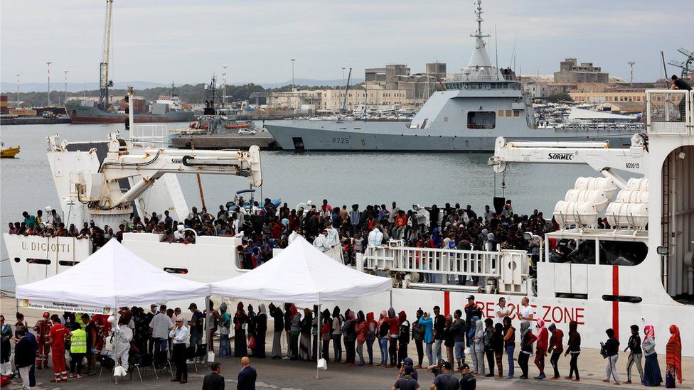 Migrants disembark Italian coast guard vessel "Diciotti" in the port of Catania, Italy