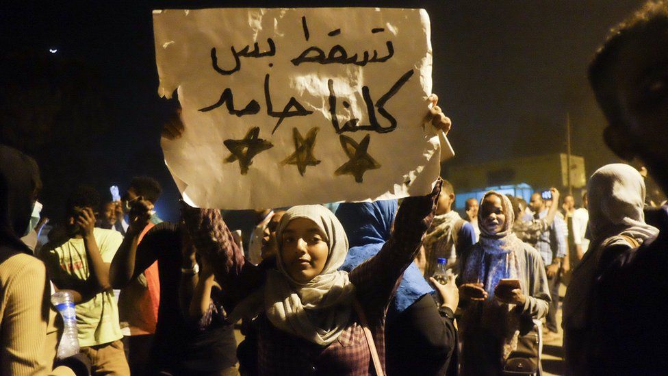 A woman holds up a sign reading: "We are all Hamid" at a sit-in at the military HQ in Khartoum, Sudan - Monday 8 April 2019