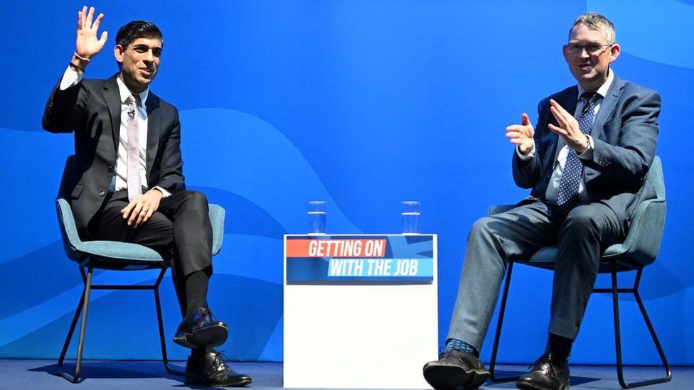 Britain's Chancellor of the Exchequer Rishi Sunak (L) speaks in conversation with MP Paul Maynard during the Conservative Party Spring Conference, at Blackpool Winter Gardens in Blackpool, north-west England on March 18, 2022.
