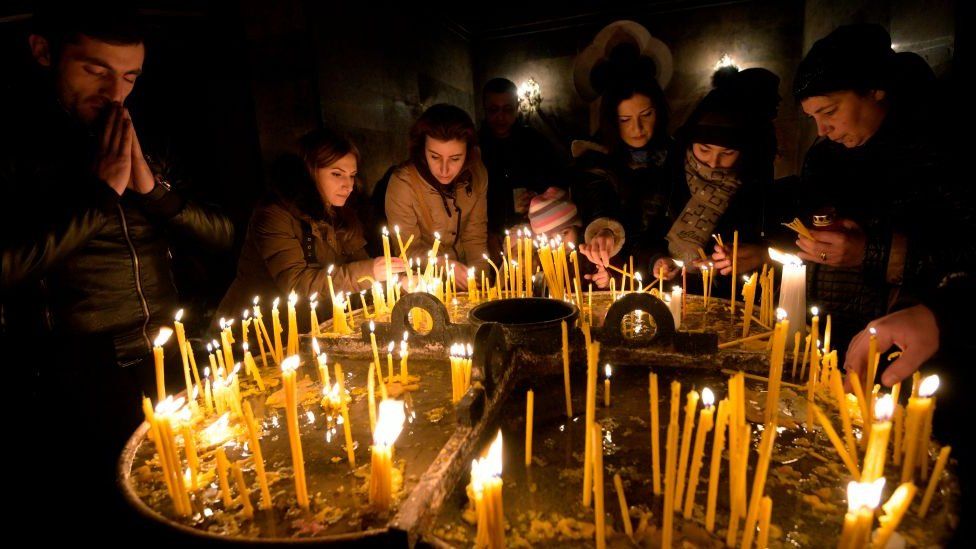 Armenians light candles on the eve of Orthodox Christmas inside a cathedral in Yerevan on 5 January 2018