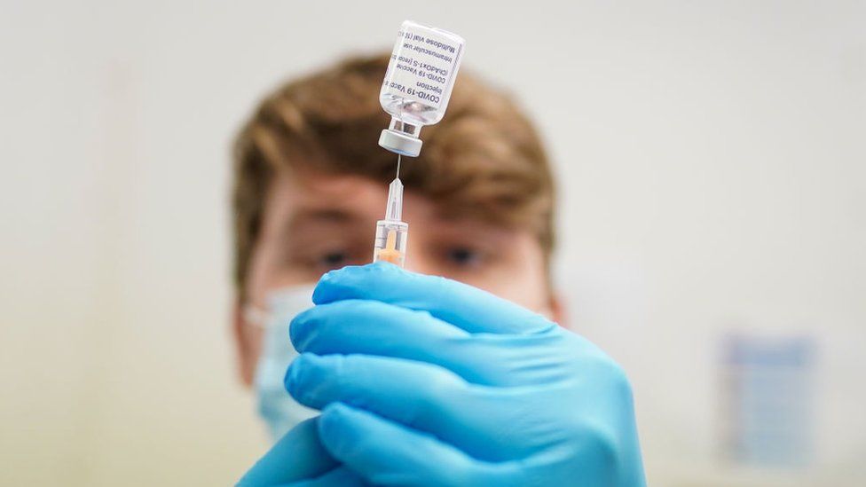 A pharmacist prepares a vaccine dose