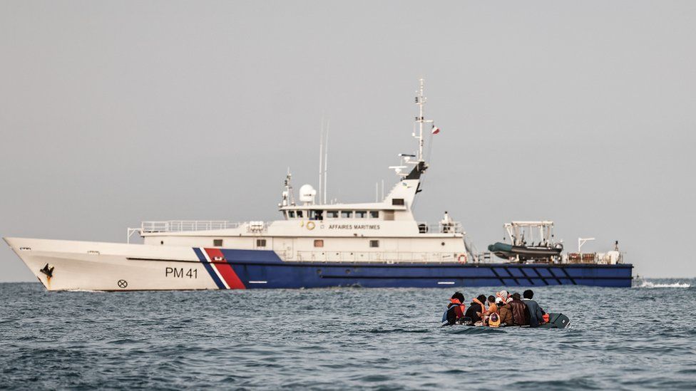 A French patrol vessel approaches a migrant's dinghy in the English Channel. File photo