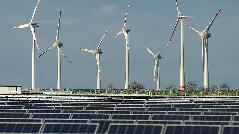 Wind turbines behind a solar power plant