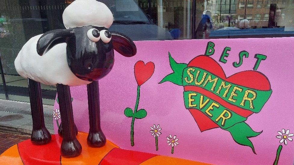 One of the smaller sheep on a bench with the words 'best summer ever'