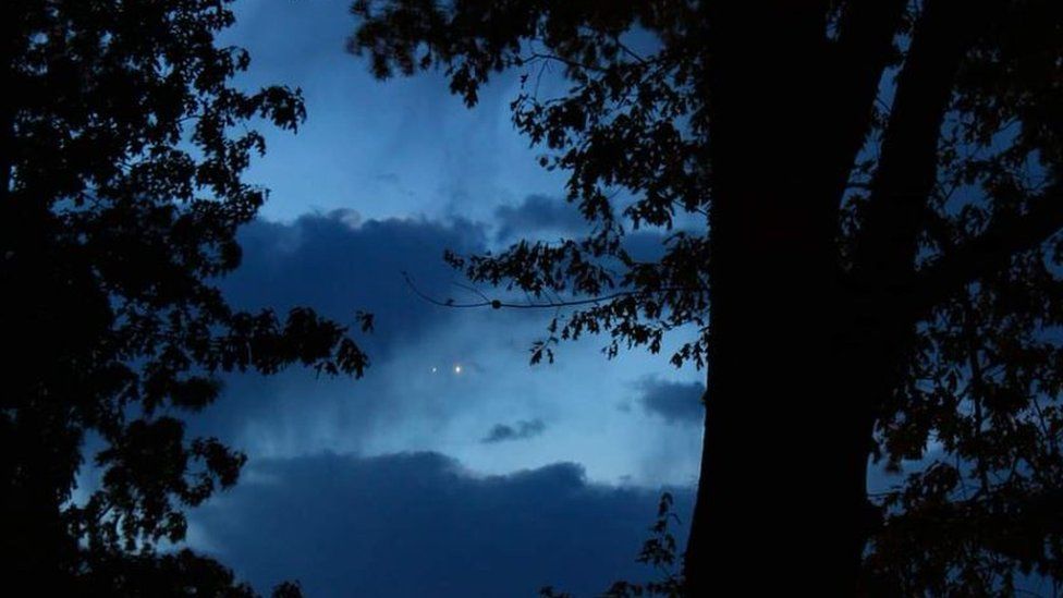 The two planets seen side-by-side between the trees in pre-dawn light