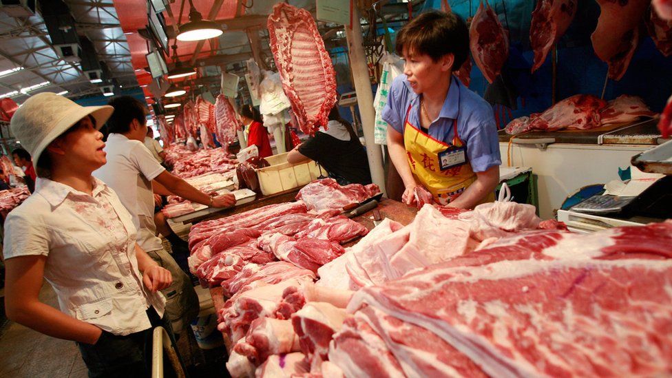 A customer shops for pork at at butcher in China