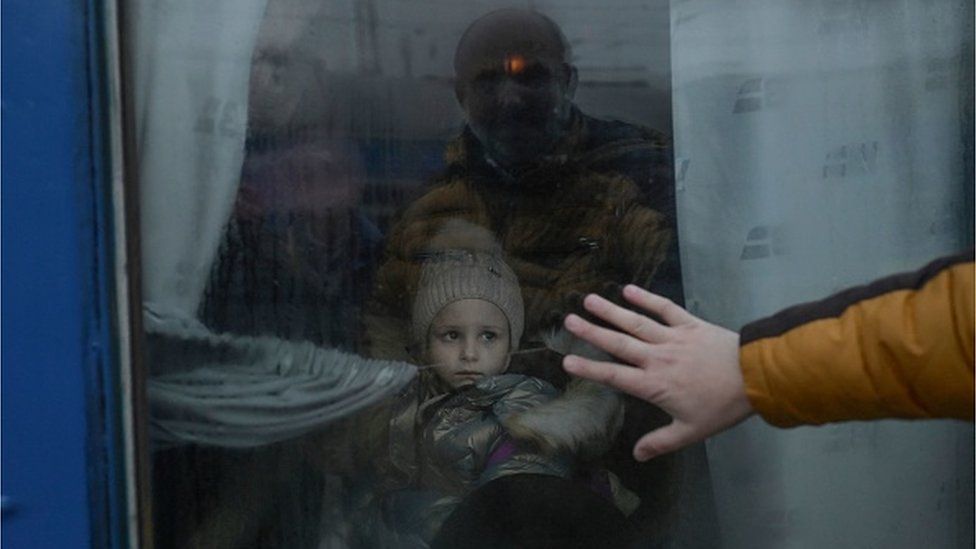 A father puts his hand on the window as he says goodbye to his daughter in front of an evacuation train at the central train station in Odessa on March 7, 2022.