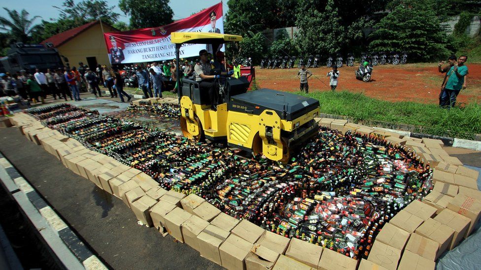 A bulldozer destroys bottles of illegal alcohol in South Tangerang, Indonesia (April 2018)