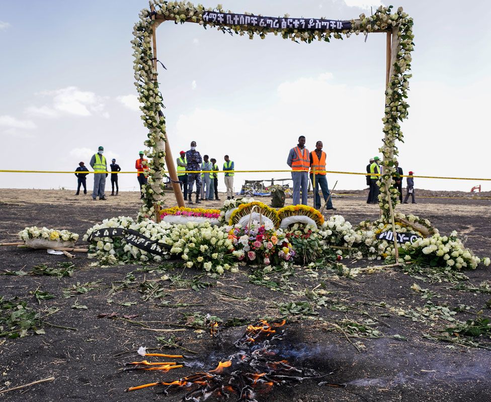Candles burn before a flower adorned memorial arch erected at the site of the Ethiopian Airlines Flight ET302 crash on March 14, 2019 in Ejere, Ethiopia.