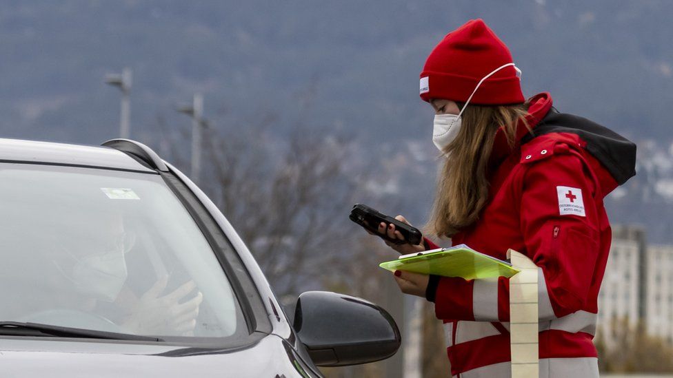 worker checks person arriving for covid test