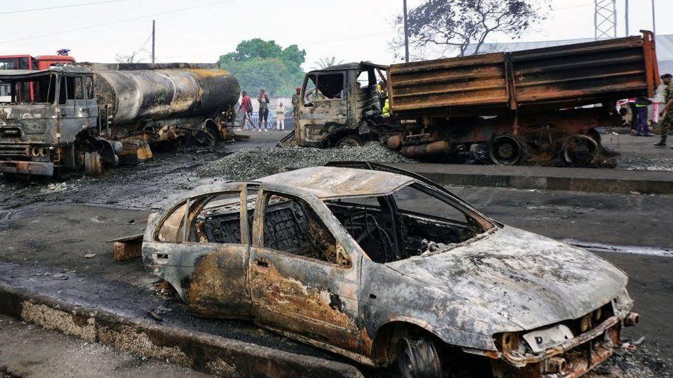 This photograph shows burnt vehicules in Freetown on November 6, 2021, following a massive explosion that has killed at least 92 people