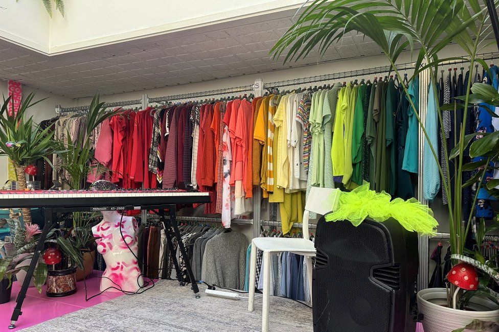 Colourful clothes hanging in swap shop at Green House
