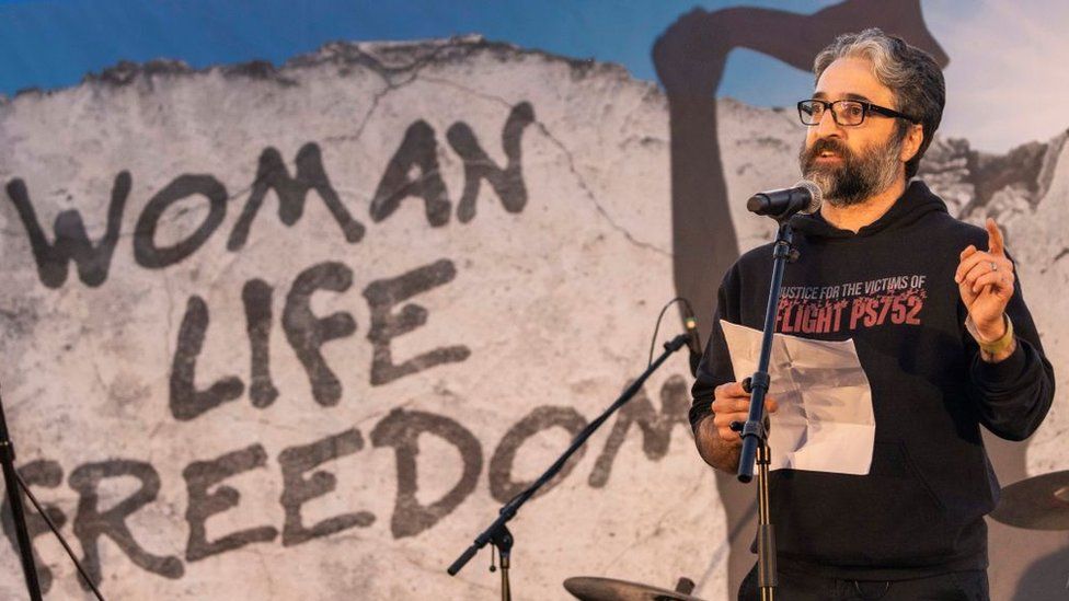 Хамед Эсмаилион выступает на митинге в Берлине, Германия, в знак солидарности с женщинами и протестующими в Иране после гибели Махсы Амини