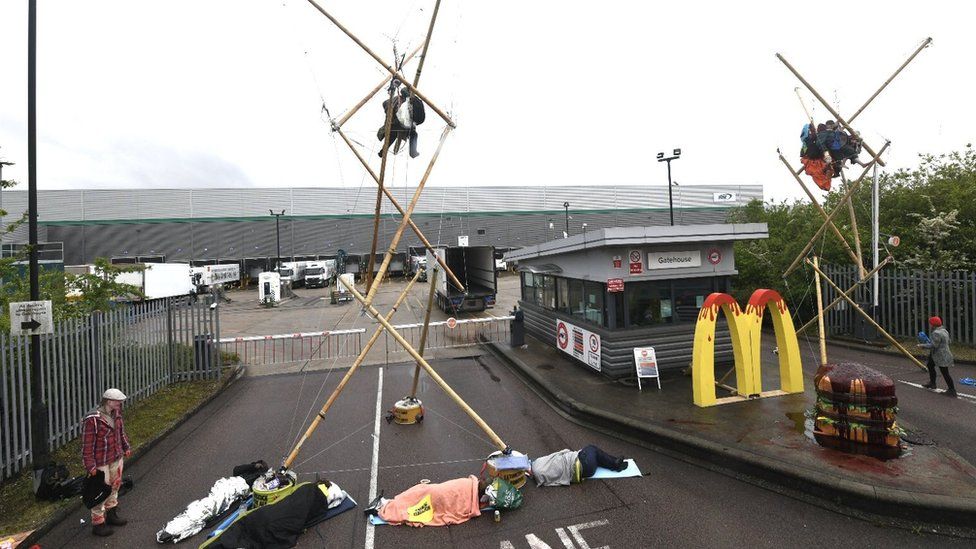 Animal Rebellion protesters suspended and attached to a bamboo structure outside a McDonalds distribution site in Hemel Hempstead