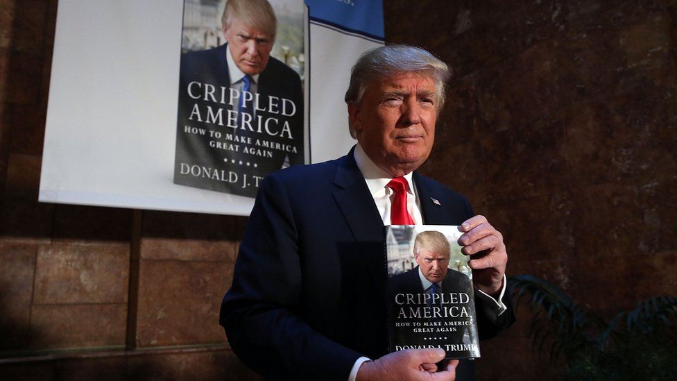 Donald Trump stands with his new book 'Crippled America: How to Make America Great Again,' before a public signing for his book at the Trump Tower Atrium on November 3, 2015 in New York City.