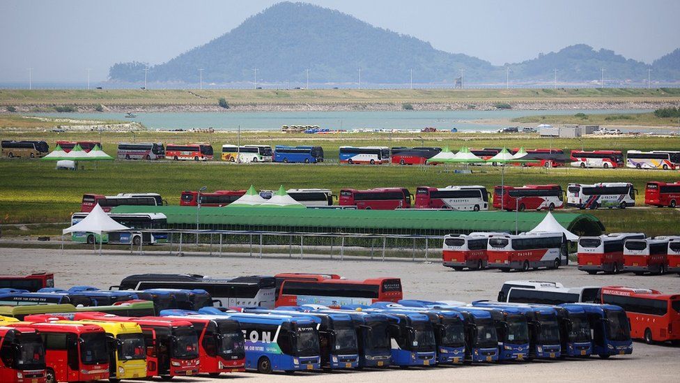 An image showing buses waiting in a long line to transport participants leaving the scout campsite
