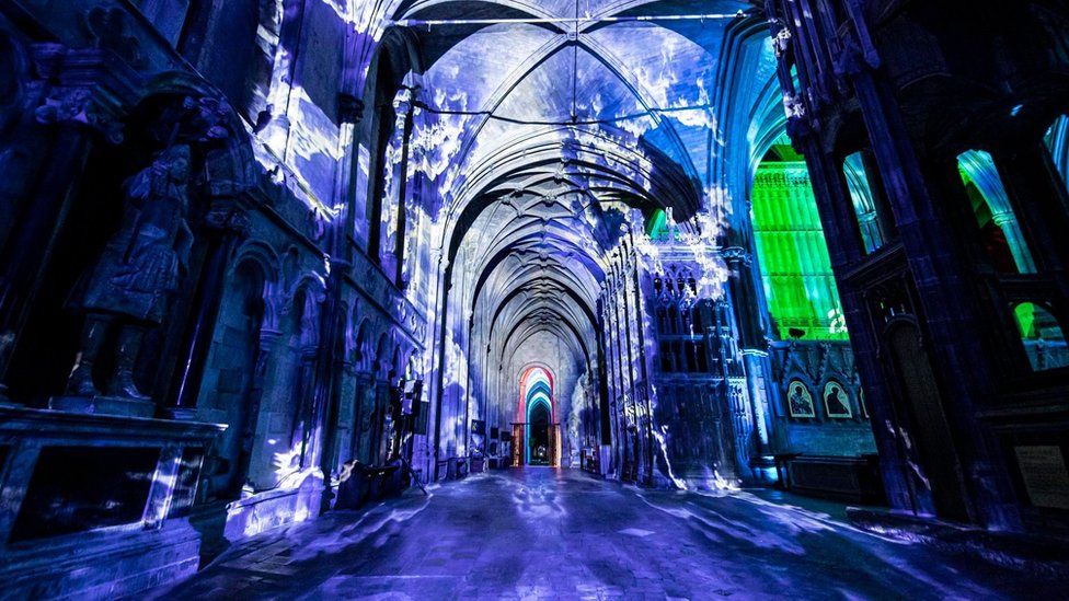 A light show signifying water on the walls of the cathedral - showing blue colours and water