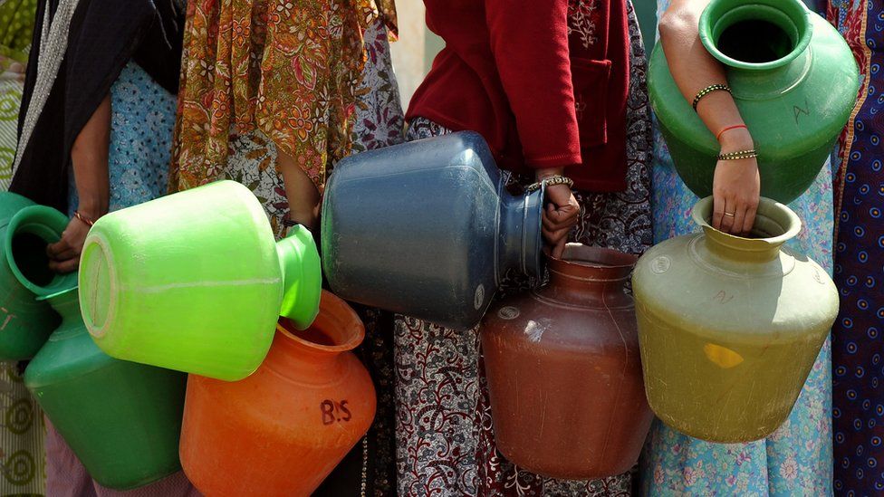 Indian residents in a district facing a drinking water shortage wait with plastic pots at a community tube well to collect drinking water in Bangalore on October 8, 2012.