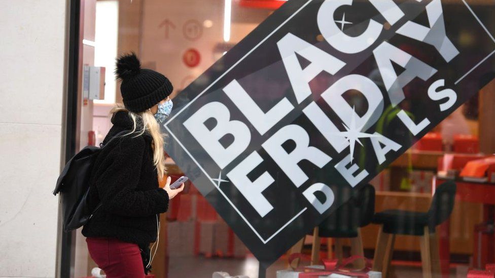 Woman walks past Black Friday promotion sign