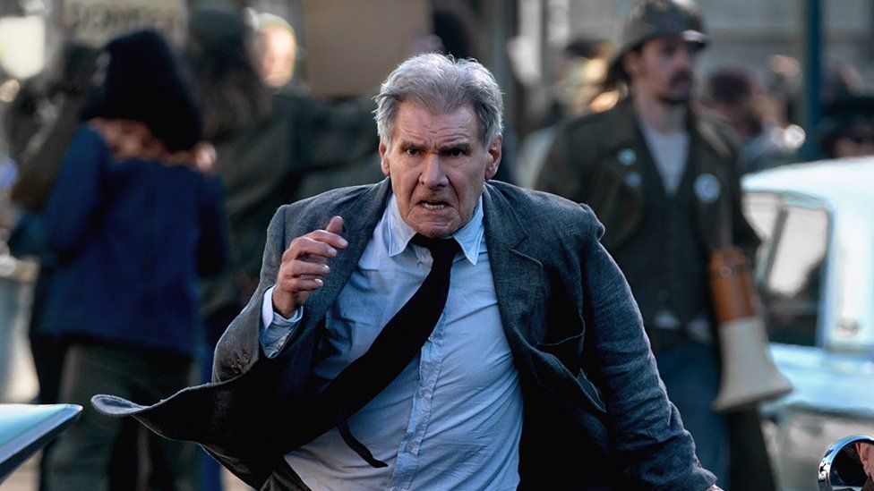 Harrison Ford running between cars