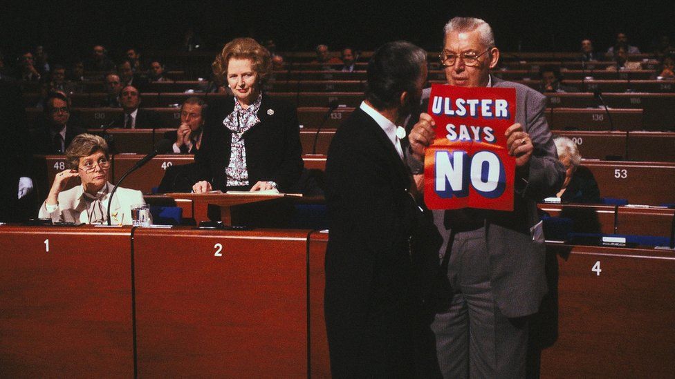 Ian Paisley holding a poster saying 'Ulster Says No' at the European Parliament