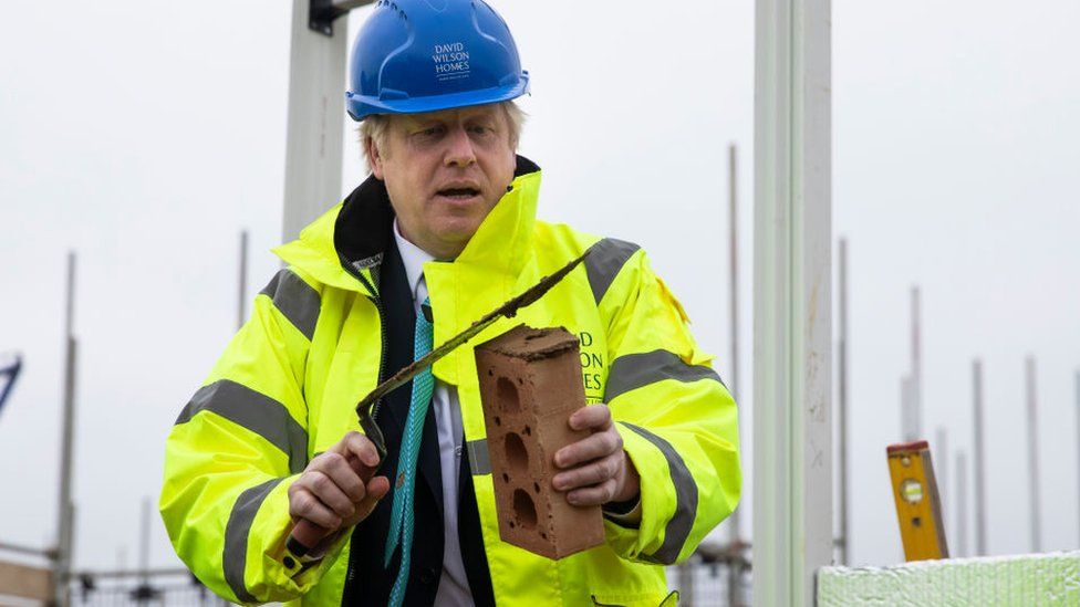 Prime Minister Boris Johnson lays a brick during a visit to the Barratt Homes - Willow Grove housing development on November 21, 2019