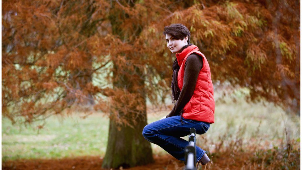 Woman sitting outdoors wearing a polo neck and gillet jacket
