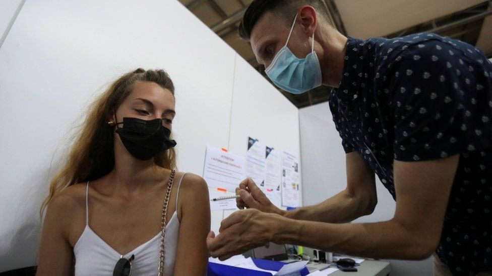 A medical worker administers a dose of vaccine in Montigny-le-Bretonneux, southwest of Paris, France