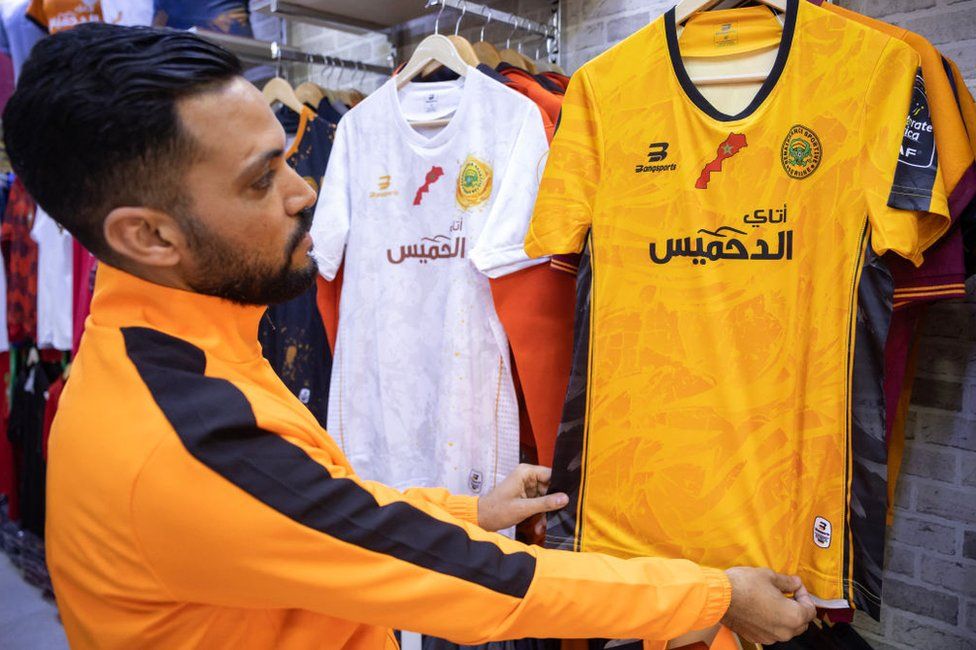 A supporter of Morocco's RS Berkane football team checks the team's jersey at a shop in the city of Berkane.