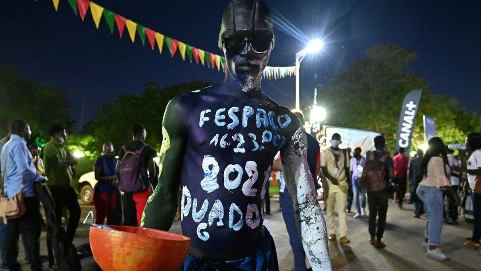 Man with white paint on his chest which reads: FESPACO