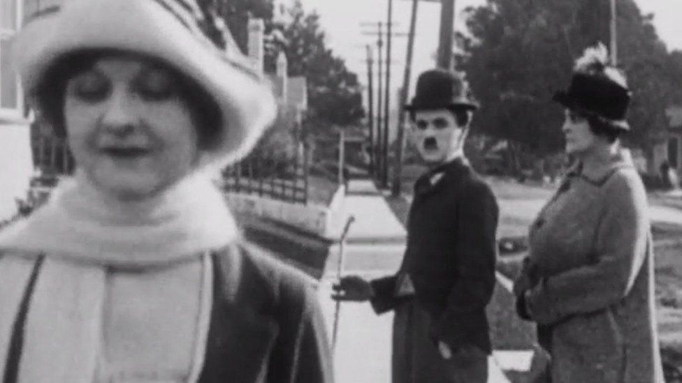 Charlie Chaplin watches as a woman passes by. Beside Chaplin, what we assume to be his wife looks angrily at him. It is visually very similar to the distracted boyfriend meme that was popular in 2017.