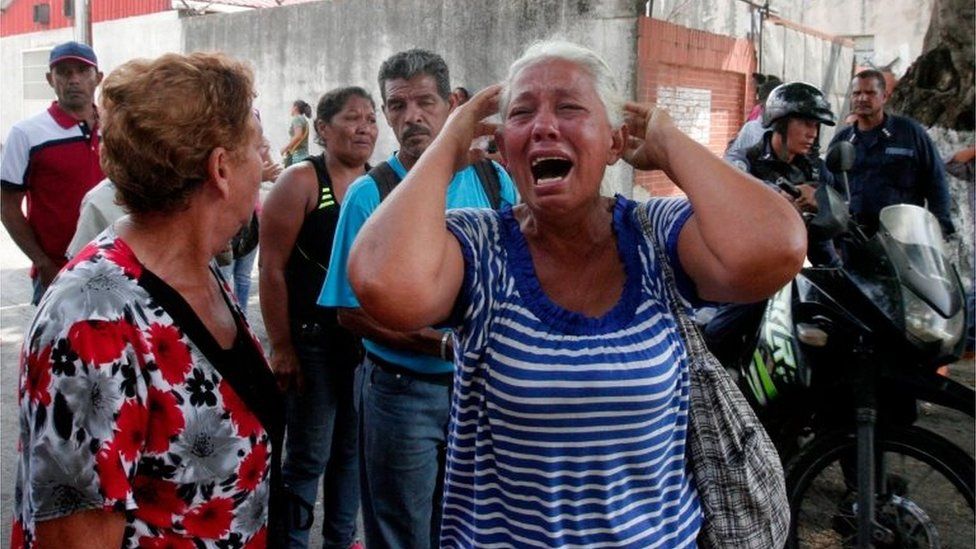 A relative of a prisoner cries in front of a police station in Valencia on March 28, 2017, after a fire engulfed police holding cells that resulted in the deaths of 68 people