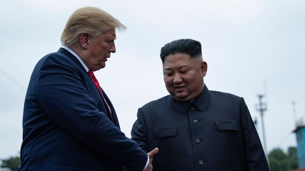 US President Donald Trump and North Korea's leader Kim Jong-un shake hands